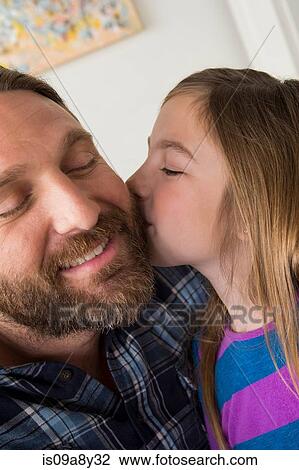 Stock Image - Daughter kissing father's cheek. Fotosearch