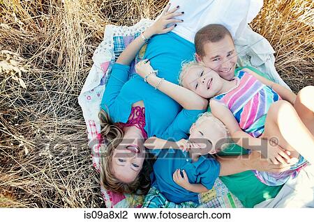 Family with two children lying in field View Large Photo Image Stock Image - Family with two children lying in field. Fotosearch