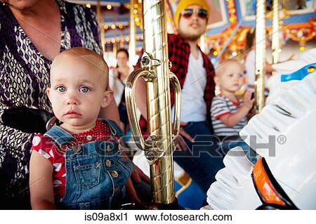 Stock Image - Family with two children on carousel. Fotosearch