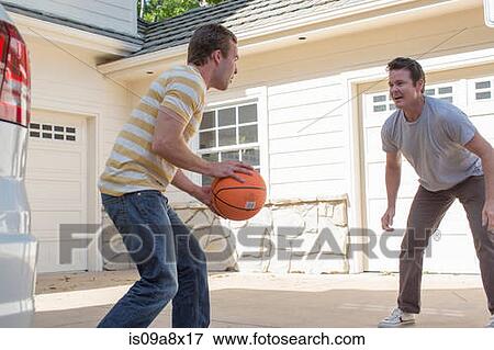 Stock Photo - Father and adult son playing basketball. Fotosearch