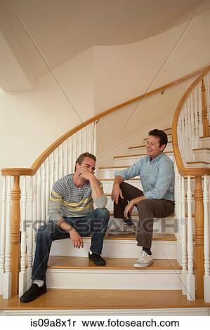 Stock Photography - Father and adult son sitting on stairs. Fotosearch