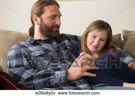 Stock Photo - Father and daughter chatting on couch. Fotosearch
