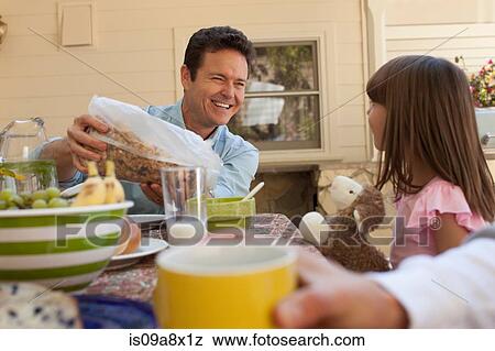 Stock Photo - Father and daughter having breakfast outdoors. Fotosearch
