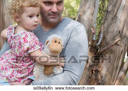 Father carrying child with soft toy View Large Photo Image Picture - Father carrying child with soft toy. Fotosearch