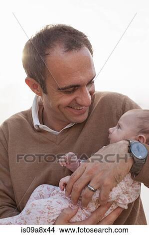 Picture - Father holding newborn baby daughter. Fotosearch