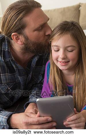 Girl looking at digital tablet with father View Large Photo Image Stock Photograph - Girl looking at digital tablet with father. Fotosearch