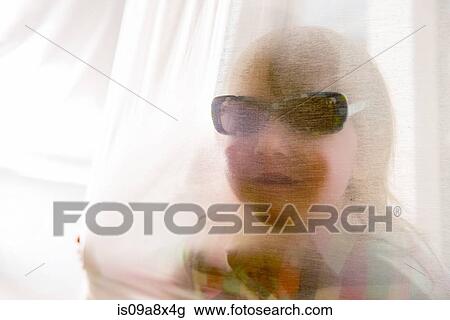 Girl looking through curtain wearing sunglasses View Large Photo Image Stock Image - Girl looking through curtain wearing sunglasses. Fotosearch