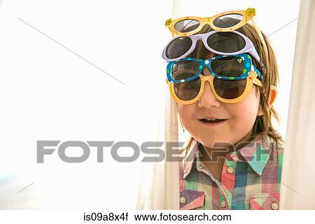 Stock Image - Girl wearing four paris of sunglasses. Fotosearch