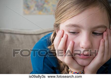 Girl with hands on face looking down View Large Photo Image Stock Photograph - Girl with hands on face looking down. Fotosearch
