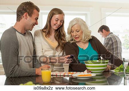 Grandchildren with grandmother holding smartphone View Large Photo Image Stock Photo - Grandchildren with grandmother holding smartphone. Fotosearch
