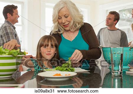 Granddaughter and grandmother preparing salad View Large Photo Image Stock Image - Granddaughter and grandmother preparing salad. Fotosearch