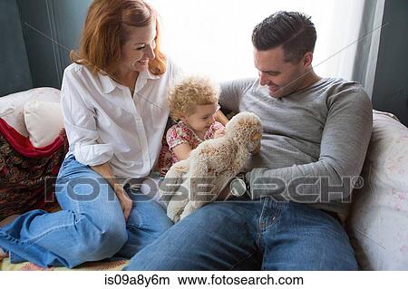 Husband & wife entertaining child View Large Photo Image Picture - Husband & wife entertaining child. Fotosearch