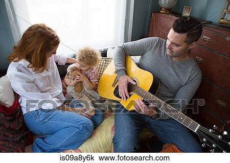 Husband & wife entertaining child View Large Photo Image Stock Image - Husband & wife entertaining child. Fotosearch
