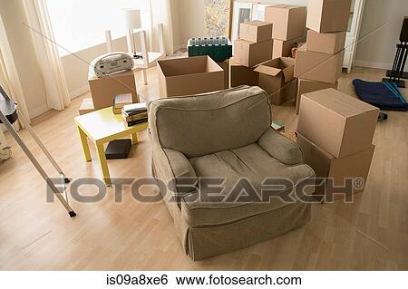 Stock Photograph - Living room with armchair and cardboard boxes. Fotosearch