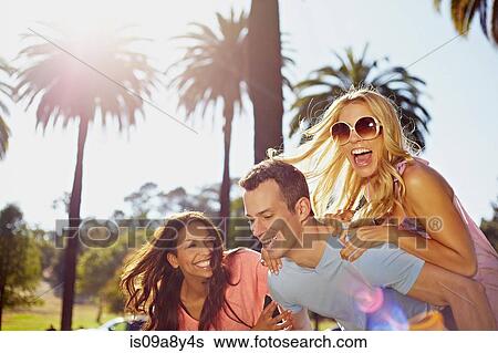 Man and women playing piggy back View Large Photo Image Stock Photograph - Man and women playing piggy back. Fotosearch