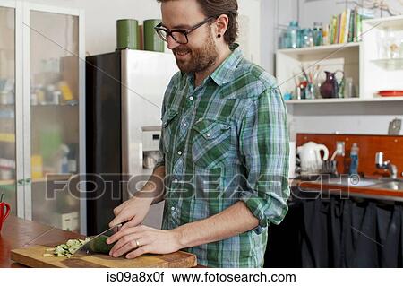 Stock Image - Man chopping vegetables. Fotosearch