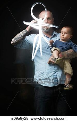 Man drawing to entertain baby in arms View Large Photo Image Stock Photo - Man drawing to entertain baby in arms. Fotosearch
