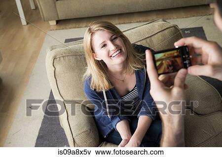 Man photographing young woman on cell phone View Large Photo Image Stock Photo - Man photographing young woman on cell phone. Fotosearch