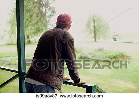 Man standing on verandah looking at garden View Large Photo Image Stock Photo - Man standing on verandah looking at garden. Fotosearch