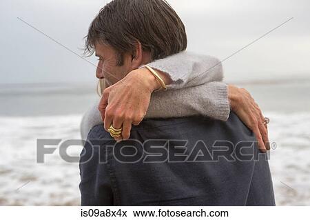 Stock Photo - Mature couple embracing on beach. Fotosearch