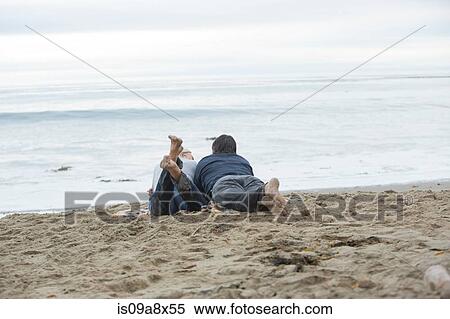 Mature couple lying on beach looking at sea View Large Photo Image Stock Photography - Mature couple lying on beach looking at sea. Fotosearch