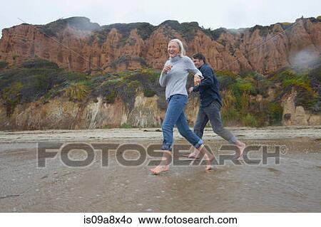 Mature couple running on beach View Large Photo Image Picture - Mature couple running on beach. Fotosearch
