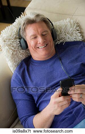 Mature man wearing headphones, smiling View Large Photo Image Stock Photograph - Mature man wearing headphones, smiling. Fotosearch