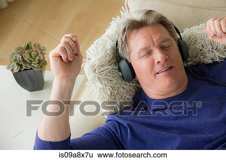 Mature man wearing headphones, smiling View Large Photo Image Stock Photograph - Mature man wearing headphones, smiling. Fotosearch