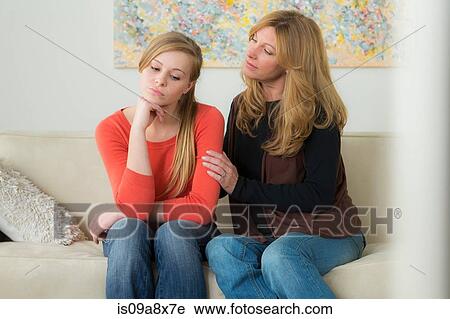 Stock Image - Mature woman comforting teenage daughter. Fotosearch