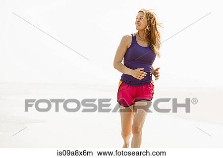 Mature woman jogging by coast View Large Photo Image Picture - Mature woman jogging by coast. Fotosearch