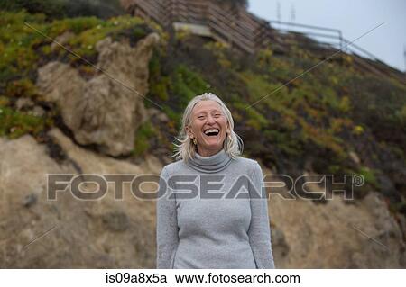 Mature woman laughing on beach View Large Photo Image Stock Image - Mature woman laughing on beach. Fotosearch