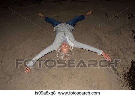 Mature woman lying on sand with arms and legs out View Large Photo Image Stock Photo - Mature woman lying on sand with arms and legs out. Fotosearch