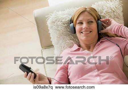 Stock Photography - Mature woman wearing headphones, smiling. Fotosearch