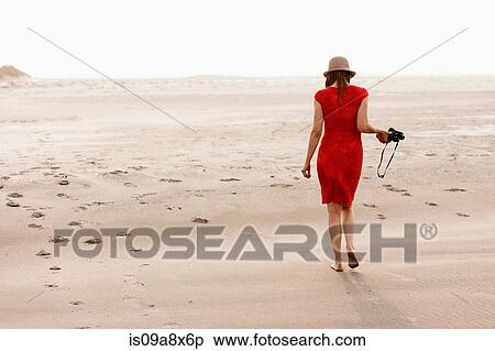Mature woman wearing red dress walking on beach View Large Photo Image Stock Photography - Mature woman wearing red dress walking on beach. Fotosearch