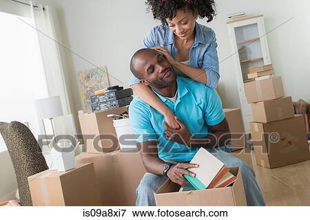 Mid adult couple moving in to new home View Large Photo Image Stock Photo - Mid adult couple moving in to new home. Fotosearch