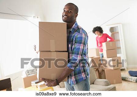 Stock Photo - Mid adult man carrying cardboard boxes. Fotosearch
