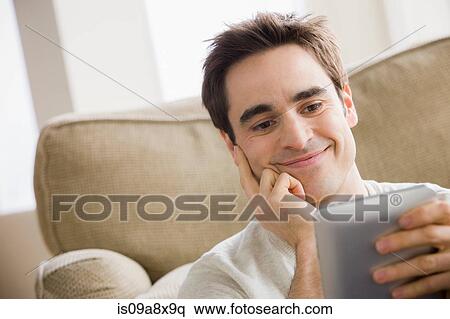 Mid adult man holding electronic reader View Large Photo Image Stock Photography - Mid adult man holding electronic reader. Fotosearch