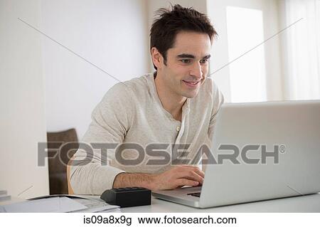 Mid adult man using laptop, smiling View Large Photo Image Stock Image - Mid adult man using laptop, smiling. Fotosearch
