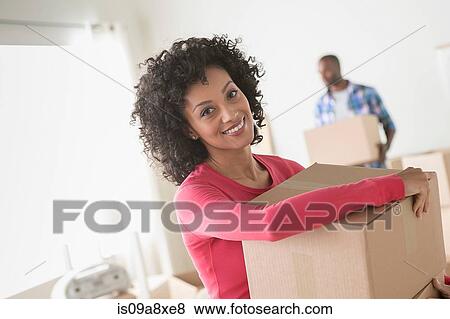 Mid adult woman carrying cardboard boxes View Large Photo Image Stock Photo - Mid adult woman carrying cardboard boxes. Fotosearch