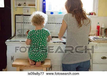 Stock Photo - Mother and child at kitchen sink. Fotosearch