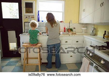 Stock Photograph - Mother and child at kitchen sink. Fotosearch