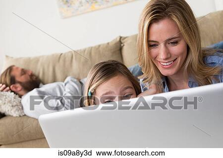 Stock Image - Mother and daughter looking at laptop. Fotosearch