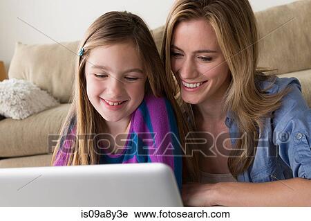 Mother and daughter looking at laptop View Large Photo Image Stock Image - Mother and daughter looking at laptop. Fotosearch