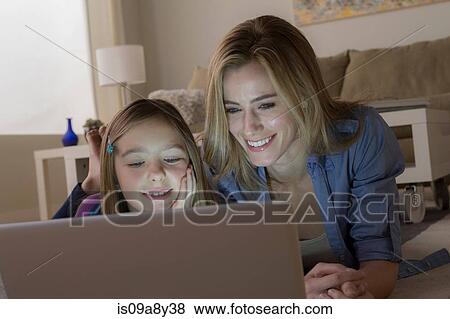 Stock Photo - Mother and daughter looking at laptop. Fotosearch