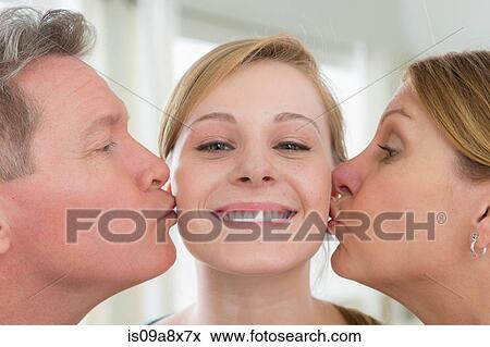 Mother and father kissing teenage daughter on cheek View Large Photo Image Stock Photo - Mother and father kissing teenage daughter on cheek. Fotosearch