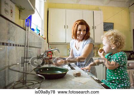 Stock Photo - Mother at sink smiling at child. Fotosearch