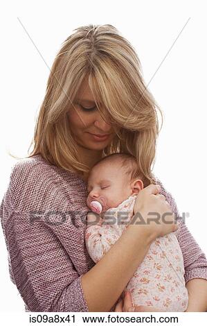 Stock Image - Mother holding newborn baby daughter. Fotosearch