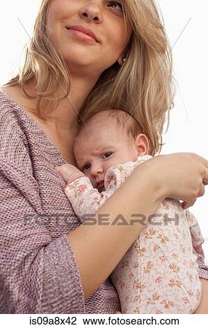 Stock Image - Mother holding newborn baby daughter. Fotosearch