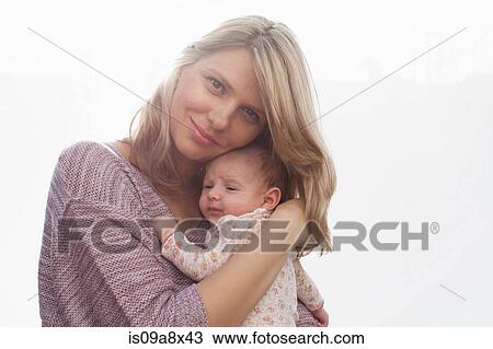 Stock Image - Mother holding newborn baby daughter. Fotosearch