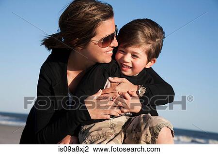 Stock Image - Mother hugging son. Fotosearch